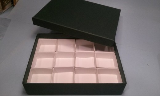 Estuche verde de cartón con 12 cajas de 4x4 cm.